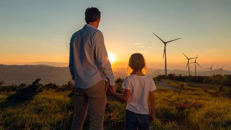 Hombre y niña observando fuentes de energía renovables